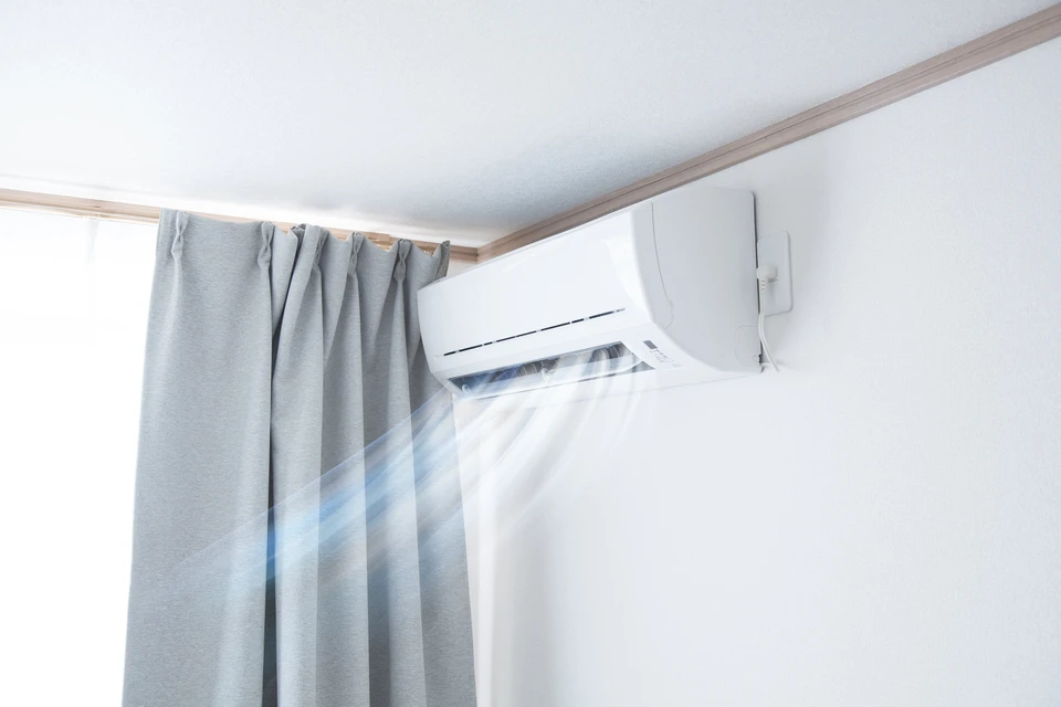 Intérieur résidentiel avec climatiseur mural split en fonctionnement, diffusant de l'air froid visible