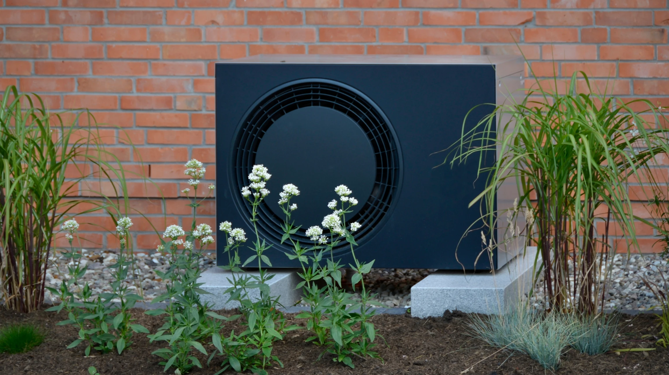 Extérieur d'un bâtiment résidentiel avec unité de climatisation installée sur mur en briques beiges