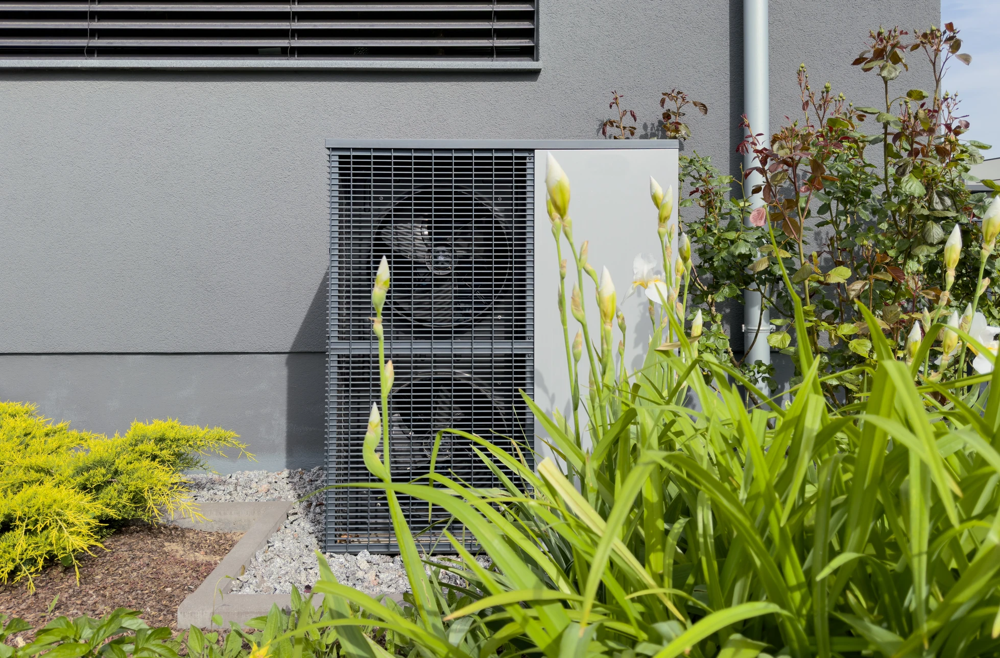 Façade extérieure d'habitation moderne avec pompe à chaleur air-eau installée